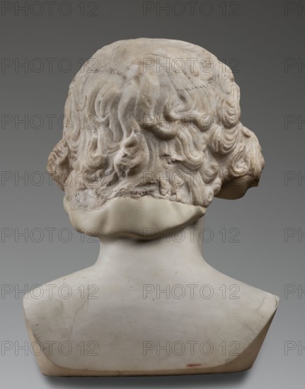 Portrait of Antinous, unknown Roman workshop; male portrait bust, Roman sculpture, 130–138 CE, Roman Empire 27 BC–476; sculpture; weight 59.5 kg; height 54 cm; width 40 cm; depth 32 cm., The image shows the rear view of a sculpted bust with a carved hairstyle of wavy, curled locks atop a smooth neck and shoulders; the hair area has a textured, weathered surface with subtle pits and variations, and the lower neck and shoulder area appears smoother and more polished. The colors visible include shades of off-white, cream, beige, light tan, and areas of gray. The background is a uniform gray.