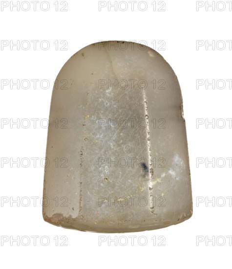Stamp seal with a scene of adoration of divine symbols, unknown Neo-Babylonian workshop. On the octagonal, slightly convex base of the seal, there is a scene, schematically executed in concave relief, of a standing figure priest? adoring divine emblems placed on a two-story openwork platform altar?. The emblems on the platform are interpreted as a spade, an attribute of Marduk, and a stylus, an attribute of Nabu, the god of scribes, wisdom and magic. At the top of the scene, two astral symbols are shown — a star and a crescent moon, identified with Shamash the sun god and Sin the moon god. 6th century BC; Neo-Babylonian period, Southern Mesopotamia Babylonia, Iraq. Seal; height 3.2 cm, width 2.5 cm, depth 1.45 cm., A single rounded, dome-shaped object with a smooth, slightly translucent surface in shades of off-white, beige, and pale yellow, showing areas of cloudy white mottling and faint brownish spots; the surface has several shallow scratches and scuff marks, a vertical groove runn...