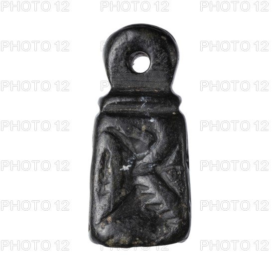 Stamp seal with figural representations. Stamp seal in the form of a truncated pyramid on a square base, terminated with a round handle. The four side walls and the base are decorated with engraved, stylized figurative representations: two opposite sides depict a rider on a horse; one of the other sides depicts a striding figure holding a staff topped with a star; the opposite wall depicts an animal being attacked by a bird of prey. A winged animal is engraved on the seal's base. Glyptics; figural motifs; Eastern Gallic scenes. 9th–6th century BC, Iron Period. Northwestern Syria; Near East. Seal. Height 2.8 cm; width 1.3 cm; depth 1.4 cm. Seal impression carrier length 8.5 cm; width 4.4 cm., A small dark pendant shaped like a flattened rectangle with a rounded top and a circular hole near the top, showing a textured surface with carved or worn shallow grooves and irregularities; the visible colors are predominantly black with a few spots of gray and small flecks of brown or beige.