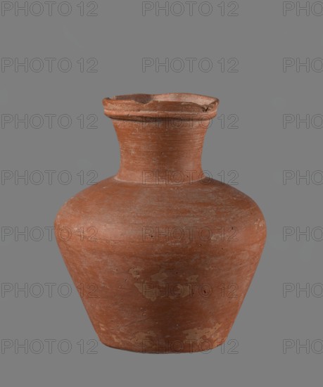 Jug with biconical belly. Vessel is widest at about half its height; shoulders broad, not very sloping. Neck wide, slightly widening toward the spout, its height about 1/3 of total. Spout profiled, irregular, slightly raised and extended on one side forming a small secondary spout; almost triangular in cross-section with ~1 mm indentation at centre of outer profile. Bottom very slightly rounded. Made of Nile clay NB1, Vienna System. Neck was made separately and joined; joint traces erased. Outer surface smoothed, covered with engobe and polished. Inner surface smoothed except for the neck, which was also covered with engobe and polished. Color reddish-brown. Condition: quite well preserved; rim slightly chipped in two places; engobe worn off in places on outer surface. Provenance: Edfu — local workshop. Chronology/style: Old Kingdom comparative types ca. 2686–2181 BC. Comparative example: Reisner, Mycerinus, fig. 69 type XIX, XX, vessel height 17.4 cm, rim Ø 8.1 cm, body Ø 15 cm, base ...