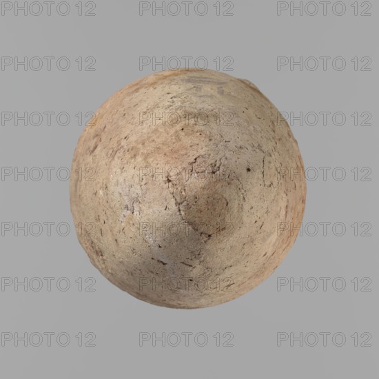 Vessel with hieratic inscription. Conical clay vessel tapering toward the bottom, irregular, widest at approx. 3/4 of the height. Narrow, slightly sloping shoulders; short, wide neck; very gently rounded, slightly flaring rim; pointed bottom. Handcrafted; upper part shoulders, neck, rim turned. Smooth surface, externally probably covered with a layer of engobe. Made of Nile clay NB2 Vienna System. Remains of a hieratic inscription in black on the lower part of the belly. Complete, well preserved. Old Kingdom, ca. 2686–2181 BC. Comparative parallels cited in literature. Dimensions: height 12.9 cm; rim diameter 5.5 cm; body diameter 7.8 cm., A roughly spherical, weathered object with a textured, cracked surface sits centered against a plain background; its surface shows a mix of beige, tan, light brown, and faint reddish tones with darker brown speckles and small pits, and the object has irregular marks and patches of slightly darker and lighter coloration across its curved form.