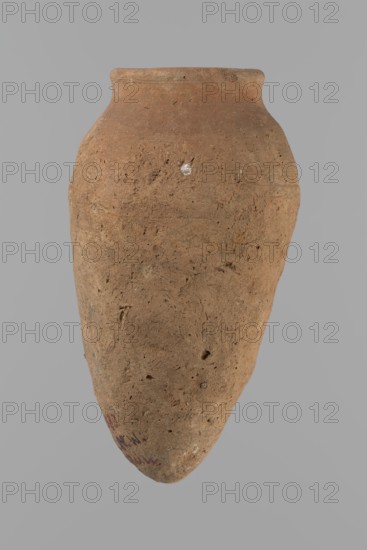 Vessel with hieratic inscription. Egyptian pottery conical vessel tapering towards the bottom, irregular, widest approx. 3/4 of the height. Narrow shoulders, only slightly sloping; short, wide neck; very gently rounded, slightly flaring rim; pointed bottom. Handcrafted; upper part shoulders, neck, rim turned. Smooth surface, externally probably covered with a layer of engobe. In the widest part three shallow horizontal lines over a space of approx. 0.8 cm. Made of Nile clay NB2 Vienna System. Remains of a hieratic inscription in black sht in the lower part of the body. Vessel complete, well-preserved. Comparative parallels cited. Old Kingdom, ca. 2686–2181 BC. Dimensions: height 14.4 cm; rim diameter 5.4 cm; body diameter 8.4 cm., A single weathered clay vessel with an elongated, tapered body and a narrow rounded rim, showing a rough, pitted surface texture and small chips, in shades of brown and tan against a neutral gray background.