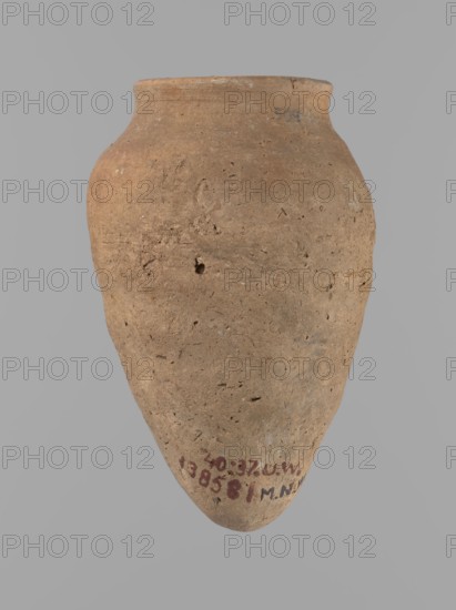 Vessel with hieratic inscription. Conical clay vessel tapering toward a pointed bottom; irregular shape, widest approx. 3/4 of the height. Narrow, only slightly sloping shoulders; short, wide neck; very gently rounded, slightly flaring rim. Handcrafted: upper part shoulders, neck, rim turned. Smooth surface, externally probably covered with a layer of engobe. Made of Nile clay NB2 Vienna System. Remains of a hieratic inscription in black in the lower part of the belly. Complete, well preserved. Old Kingdom, Edfu. Height 12.5 cm; rim diameter 5.4 cm; belly diameter 8 cm. Comparative references: Petrie Dendera, Abydos, Reisner Mycerinus; Naga ed-Der, Brunton Qau and Badari, Mace Naga ed-Der II, Keiser/Avila/Dreyer/Jaritz/Laskowska-Kusztal, ca. 2686–ca. 2181 BC., A single large earthenware vessel fills the frame, shown against a plain light gray background; the vessel has an ovoid body that tapers to a rounded point at the bottom and widens into a short neck with a slightly flared rim at ...
