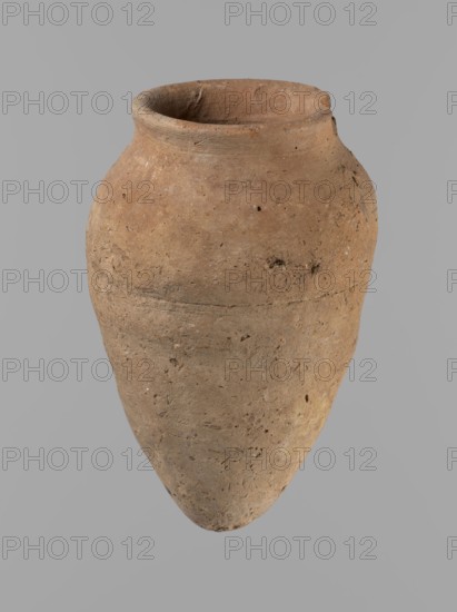 Vessel with hieratic inscription, Egyptian ceramic conical vessel clay, tapering to a pointed bottom, irregular; widest approx. 3/4 of the height. Narrow, only slightly sloping shoulders; short, wide neck; very gently rounded, slightly flaring rim. Handcrafted: upper part shoulders, neck, rim turned. Smooth surface, externally probably covered with engobe. Made of Nile clay NB2 Vienna System. Remains of a hieratic inscription in black oak on lower belly. Complete, well preserved. Old Kingdom, Edfu; height 12.5 cm, rim diameter 5.4 cm, belly diameter 8 cm. Comparative material: Petrie, Dendera pl. XVI.2; Hope, Akhmim fig.7 type AIVa 2bi; Reisner, Mycerinus p.212 fig.64; Brunton, Qau and Badari pl. LXXXI type 77N; Mace, Naga ed-Der II figs.87.11–25; Reisner, Naga ed-Der III figs.28–33; Petrie, Abydos II pl. XLIII; Keiser et al., MDAIK 40 fig.9b — ca. 2686–2181 BC., A single large clay vessel with a rounded shoulder and a tapered base sits against a plain gray background; the pot has an o...