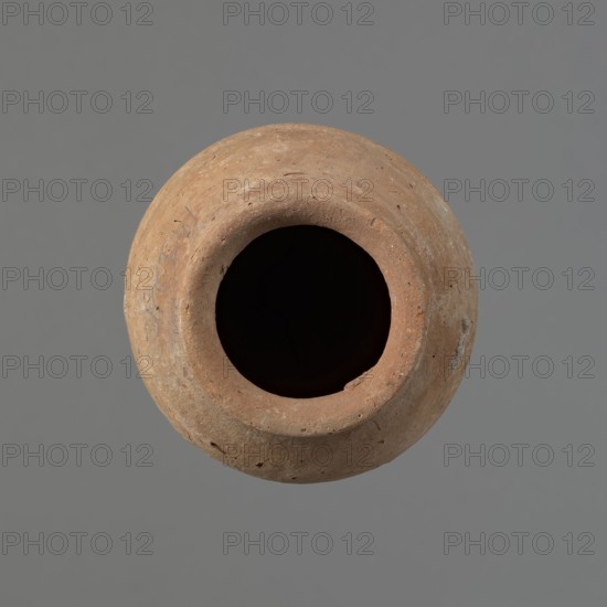 Vessel with hieratic inscription, Egyptian ceramic conical vessel tapering toward the bottom of Nile clay NB2 Vienna System. Handcrafted; upper part shoulders, neck, rim thrown on a wheel. Smooth surface, externally probably covered with engobe. Irregular, widest approx. 3/4 of the height; narrow sloping shoulders; short wide neck; very gently rounded, flaring rim; pointed bottom. Three shallow horizontal lines on the widest diameter two 0.2 cm apart, third 0.5 cm from second made before firing. Remains of a hieratic inscription in black on the lower body. Rim slightly damaged. Old Kingdom, Edfu; ca. 2686–2181 BC. Dimensions: height 16 cm; rim diameter 6.3 cm; body diameter 9.4 cm. Analogies: Petrie Dendera, Abydos, Hope Akhmim, Reisner Mycerinus, Naga ed-Der, Brunton Qau and Badari, Mace Naga ed-Der II, Keiser/Avila/Dreyer/Jaritz/Laskowska-Kusztal MDAIK 40, fig. 9b., A round clay vessel viewed from above showing a wide circular opening and a dark interior, the exterior surface texture...