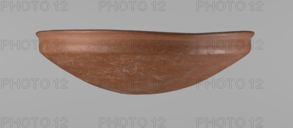Medum-type bowl, Medum-type bowl with characteristic carination under the rim. Rounded bottom. Straight rim, slightly flaring. Narrow, very sloping shoulders — almost vertical. The diameter of the rim is larger than the diameter of the shoulders. Clay probably NB. Surface leveled and covered with a layer of engobe, then polished. Vessel color red. Vessel complete, very well preserved. Comparative material: Junker, Giza I, pl. I,2,16, c. 2686–c. 2181 BC; Old Kingdom late Old Kingdom, Edfu; vessel height 7.5 cm, diameter 25.8 cm rim, diameter 25.2 cm shoulders., A shallow, rounded clay bowl viewed from the side, showing a curved rim and a smooth exterior surface with visible wear marks and scratches; the bowl is primarily terracotta brown with variations of lighter brown and small patches of pale gray, set against a plain light gray background.