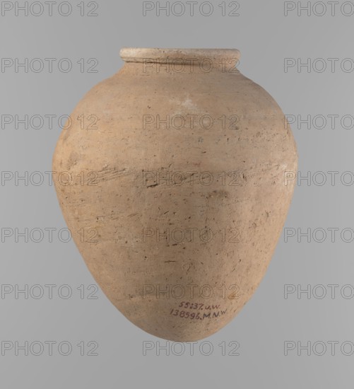 Vessel, Ovoid clay vessel with slightly downward-stretched shape, widest at about 2/3 of the height. Broad shoulders, very short wide neck; roller-shaped rim oval in cross-section and slightly flaring. Rounded bottom. Made of clay with significant organic temper Viennese system. Handcrafted from two joined parts join at ~2/3 height, turned in the upper part. Surface leveled; traces of a white substance on outer body and rim in places. Beige color. Complete, well-preserved. Late Old Kingdom ca. 2686–2181 BC. Height 24.9 cm; rim diameter 10.2 cm; body diameter 20.7 cm. References to typology and parallels in late Old Kingdom pottery., A large rounded clay vessel with a narrow neck and a slightly flared rim, showing a rough textured surface with visible tool marks and small pits; the vessel is predominantly light brown and tan with areas of darker brown and subtle pale discoloration, set against a neutral gray background.