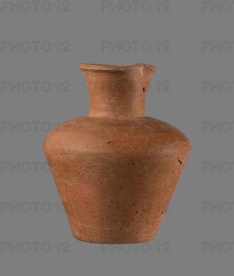 Jug, Egyptian pottery jug, cylindrical with flaring neck; clay vessel; Old Kingdom, c. 2686–c. 2181 BC; from Edfu; height 18.6 cm; rim diameter 8.5 cm; body diameter 15.8 cm; bottom diameter 9.1 cm., A clay vessel with an overall warm reddish-brown color sits against a neutral gray background; the vessel has a rounded shoulder that tapers to a slightly flared neck and an uneven rim, with visible surface texture including small pits, scratches, and hairline cracks in darker brown and black tones, and a few lighter worn spots on the base and rim.