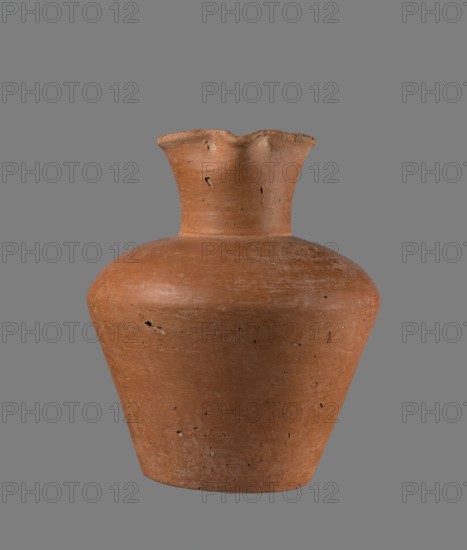 Jug, Egyptian pottery, clay vessel jug, cylindrical with flaring neck, Old Kingdom, c. 2686–c. 2181 BC, from Edfu; height 18.6 cm, rim diameter 8.5 cm, body diameter 15.8 cm, bottom diameter 9.1 cm., A terracotta-colored clay vessel with a rounded shoulder, tapered body, and a flared, scalloped rim sits against a solid gray background; the surface shows a few small pits and irregularities, subtle horizontal striations, and variations in the reddish-brown and orange-brown hues, with darker specks and slightly lighter worn areas.