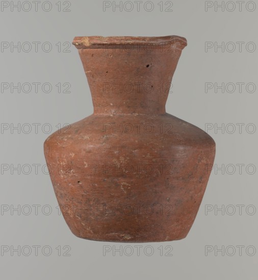 Vessel, Medium-sized clay jug with a biconical body, widest at about half its height; wide shoulders and an almost cylindrical neck that widens toward the profiled, irregular spout. The neck is about one-third of the vessel's height and appears to have been made separately and joined to the shoulders. The spout is slightly raised and extended on one side, forming a small triangular-cross-section pour; an approximately millimeter-sized cylindrical bulge is present on the outer profile. Bottom nearly flat with slight rounding. Outer and inner surfaces smoothed; both surfaces except interior of neck covered with engobe and polished. Made of Nile clay NB1? per Vienna System. Color reddish-brown. Good preservation with the rim slightly chipped in two places and some wear to the engobe. Dated c. 2345–c. 2181 BC, Old Kingdom, 6th Dynasty, from Edfu. Vessel; height 17 cm, rim diameter 9.8 cm, body diameter 14.6 cm, bottom diameter 9.5 cm. Comparable form: Saqqara II cat. 210–211 form 35; simil...