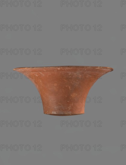 Bowl, Deep, cup-shaped bowl with a slightly convex bottom and sides arching upwards. Straight rim, flat on top, flaring. Made of Nile clay NB1 ? and covered with an engobe with added red ochre, thoroughly polished. Color: red. Well-preserved, with slight damage to the clay on the rim. Comparative parallels cited IV–VI dyn.; late VI dynasty; IV dynasty; Old Kingdom, ca. 2686–2181 BC. Place of origin: Edfu. Dimensions: height 13.8 cm; rim diameter 28.8 cm; bottom diameter 11.9 cm., A terracotta-colored, flared ceramic vessel with a wide rim and a narrower base, showing surface scratches and worn patches, photographed against a uniform gray background.