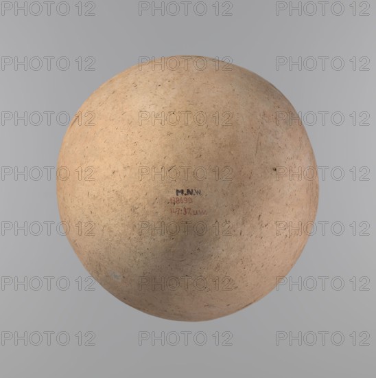 Vessel of an ovoid, slightly downward-stretched shape, widest at about 2/3 of the height. Broad, sloping shoulders, very short, wide neck. Roller-shaped rim, oval in cross-section, slightly flaring. Rounded bottom. NB2 clay according to the Viennese System with a significant amount of organic admixture. The vessel is hand-made from two parts and joined at about 2/3 of the height, turned in the upper part. Surface leveled covered with a layer of engobe?. Traces of a white substance in places on the outer surface of the body and on the rim. Vessel colour – beige. Well-preserved vessel. Ca. 2686–2181 BC; Old Kingdom, Edfu. Vessel; height 34.6 cm, diameter 11.6 cm rim, diameter 29 cm body., A roughly spherical, textured object with a worn, earthy surface fills the center of the image, showing colors of light tan, beige, pale brown, and hints of muted peach and gray, with small dark specks and fine scratches across its surface; the background is a smooth gradient of gray tones.