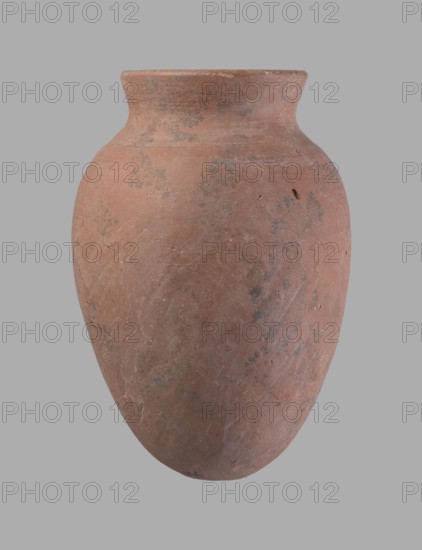 Vessel, Egyptian pottery ceramic clay vessel, c. 2686–c. 2181 BC Old Kingdom ?, from Edfu; vessel, height 16.5 cm, rim diameter 7.6 cm, belly diameter 11.2 cm., A single rounded ceramic jar with a narrow neck and flared rim sits against a plain background; the jar is mainly reddish-brown with patches of darker gray and subtle variations in terracotta tones, showing a matte, slightly rough surface with small pits and areas of wear, and a few faint lighter streaks and speckles across its body.