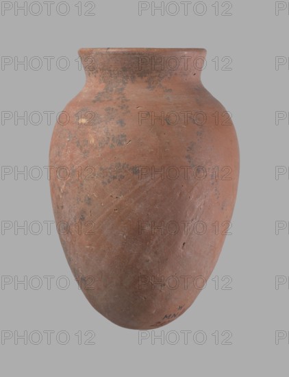 Vessel, Egyptian pottery clay vessel, c. 2686–c. 2181 BC Old Kingdom?, from Edfu; vessel, height 16.5 cm, rim diameter 7.6 cm, belly diameter 11.2 cm., A large rounded clay vessel with a narrow flared rim, shown against a plain gray background; the surface of the vessel is predominantly reddish-brown with areas of darker grayish mottling and small lighter worn spots, and it shows a rough, slightly pitted texture with visible scratches and imperfections.