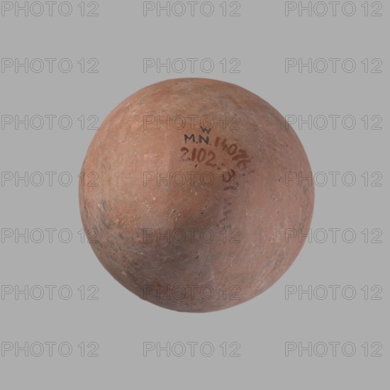 Vessel, Egyptian pottery vessel of clay, c. 2686–c. 2181 BC Old Kingdom?, from Edfu; height 16.5 cm, rim diameter 7.6 cm, belly diameter 11.2 cm., A round, weathered object with an uneven surface in shades of reddish brown and terracotta, showing areas of darker brown and subtle grayish patches, set against a plain light gray background; the surface has small pits and scuffs and a few darker smudges.