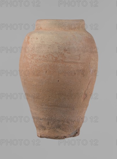 Vessel, beer jug of slightly irregular conical shape with a wide, very short neck and flat bottom; flat, narrow shoulders and gently rounded, straight rim. Wheel-made of Nile clay type NB2 Vienna System. Bottom cut off with string and bears clear potter's fingerprints, flaring slightly at its lowest part. Surface even; red color. Complete and fairly well preserved, with minor damage to the bottom. New Kingdom, ca. 1550–1069 BC; from Edfu. Dimensions: height 24 cm; rim diameter 10 cm; body diameter 16 cm; bottom diameter 9.2 cm., A single large rounded earthenware vessel with a narrow flat rim, showing a rough textured surface in shades of terracotta and beige with subtle variations and mottling, set against a uniform neutral gray background.