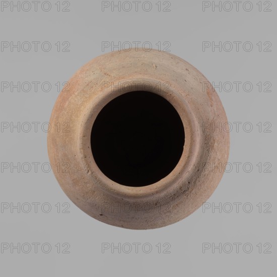 Vessel, Beer jug of a slightly irregular, conical shape with a wide, very short neck and a flat bottom. Flat, narrow shoulders and a gently rounded, straight rim. Wheel-made of Nile clay type NB2 Vienna System. The bottom is cut off with string and bears clear potter's fingerprints, flaring slightly in its lowest part. Surface even; color red. Complete and fairly well preserved, with minor damage to the bottom. New Kingdom, ca. 1550–1069 BC; origin Edfu. Dimensions: height 24 cm; rim diameter 10 cm; body diameter 16 cm; bottom diameter 9.2 cm., A round clay vessel viewed from above with a wide circular opening revealing a dark interior, the vessel surface showing a rough texture and shades of brown, tan, and reddish-brown against a light gray background.