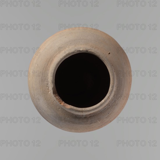 Vessel, Beer jug of a slightly irregular, conical shape with a wide, very short neck and a flat bottom. Flat, straight rim. Wheel-made from Nile clay of type NB2-ND Vienna System. Bottom cut off with string, with clear potter's fingerprints around the bottom. Surface even. Clay color: red. Vessel complete, fairly well preserved, with minor damage to the rim and small chips on the surface. ca. 1550–1069 BC New Kingdom, Edfu. Vessel; height 24.4 cm; rim diameter 9.8 cm; body diameter 16.3 cm; bottom diameter 8.5 cm., A round clay vessel viewed from above with a dark empty interior, showing a rough rim and textured exterior in shades of brown, tan, and beige against a smooth light gray background.