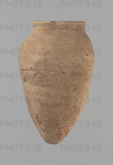 Vessel with hieratic inscription, Egyptian pottery conical clay vessel tapering toward the bottom, slightly irregular, widest at approx. 3/4 of the height. Narrow, sloping shoulders; short, wide neck; very gently rounded, widening rim; pointed bottom. Handcrafted: upper part shoulders, neck, rim turned. Around half the height a trace of joining of two separately made parts. Surface leveled, outer probably covered with a layer of engobe. Made of Nile clay Vienna System NB. Remains of a hieratic inscription in black on the lower part of the belly. Rim damaged. Analogies: parallels cited to examples illustrated by Petrie Dendera, Abydos, Hope Akhmim, Reisner Mycerinus; Naga ed-Der, Brunton Qau and Badari, Mace Naga ed-Der II, Keiser/Avila/Dreyer/Jaritz/Laskowska-Kusztal MDAIK 40 fig.9b. Dated to the Old Kingdom, ca. 2686–2181 BC. Findspot: Edfu. Dimensions: height 13.2 cm; rim diameter 5.8 cm; body diameter 8.3 cm., A roughly oval-shaped pottery vessel with a narrow neck and rounded shoul...