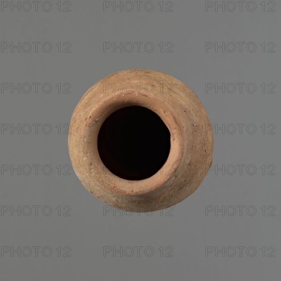 Vessel with hieratic inscription, Egyptian pottery ceramic conical vessel tapering toward a pointed bottom; irregular, widest at approx. 3/4 of the height. Narrow, slightly sloping shoulders; short, wide neck; very gently rounded, slightly flaring rim rim partially reconstructed with plaster. Handcrafted: upper part shoulders, neck, rim turned. Smooth surface, externally probably covered with an engobe. Made of Nile clay NB2 Vienna System. Remains of a hieratic inscription in black on the lower part of the belly. Old Kingdom, Edfu. Height 15.5 cm; rim diameter 6 cm; belly diameter 8.5 cm. Analogies: Petrie, Dendera pl. XVI.2; Hope, Akhmim fig.7 type AIVa 2bi; Reisner, Mycerinus p.212 fig.64; Brunton, Qau and Badari pl. LXXXI type 77N; Mace, Naga ed-Der II figs.87.11–14,16–25; Reisner, Naga ed-Der III figs.28–33; Petrie, Abydos II pl. XLIII; Keiser et al., MDAIK 40 fig.9b. Dating ca. 2686–2181 BC., A round, clay pot viewed from above with a dark interior and a rough, textured rim and bo...