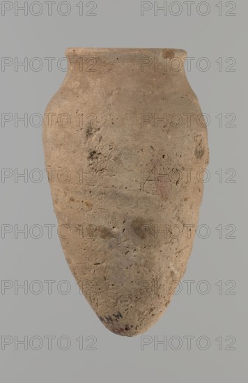 Vessel with hieratic inscription, Egyptian pottery ceramic conical vessel tapering toward the bottom, irregular, widest at approx. 3/4 of the height. Narrow, slightly sloping shoulders; short, wide neck; very gently rounded, slightly flaring rim; pointed bottom. Handcrafted, upper part shoulders, neck, rim turned. Smooth surface, externally probably covered with a layer of engobe. Made of Nile clay NB2 Vienna System. Remains of a hieratic inscription in black on the lower part of the belly. Fairly well preserved with slight damage to the rim. Old Kingdom, ca. 2686–2181 BC. Height 13.9 cm; diameter lip 5.9 cm; diameter 8 cm. Analogies: Petrie Dendera; Abydos, Hope Akhmim, Reisner Mycerinus; Naga ed-Der, Brunton Qau and Badari, Mace Naga ed-Der II, Keiser, Avila, Dreyer, Jaritz, Laskowska-Kusztal — earlier parallels dated to 4th–5th Dynasty., A single weathered clay vessel with an elongated rounded body and a slightly flared rim, shown against a plain gray background; the vessel surface ...