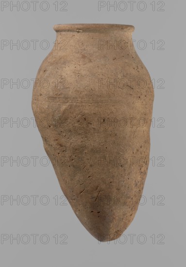 Vessel with hieratic inscription, Egyptian pottery, clay vessel, Old Kingdom ca. 2686–ca. 2181 BC, excavated at Edfu; comparative material: Petrie, Dendera, pl. XVI.2; Hope, Akhmim, fig. 7, type AIVa 2bi; Reisner, Mycerinus, p. 212, fig. 64 3,4; Brunton, Qau and Badari, pl. LXXXI type 77N — earlier dated to the IV–Vth Dynasty; Mace, Naga ed-Der II, figs. 87.11–14, 16–25; Reisner, Naga ed-Der III, fig. 28–33; Petrie, Abydos II, pl. XLIII, 79–80; Keiser et al., MDAIK 40, fig. 9b; vessel height 15.1 cm, rim diameter 5.6 cm, body diameter 8.2 cm., A large, rounded clay vessel with an elongated, tapered bottom and a slightly flared rim, shown against a plain gray background; the surface of the vessel is rough and textured with visible small pits and irregularities, and its color is predominantly brown with variations of lighter and darker brown tones and hints of tan and gray.