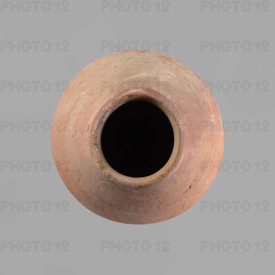 Vessel with an ovoid belly, a wide short neck and a rounded bottom. Straight, upturned rim. Wheel-made from Nile clay of type NB2 Vienna System. Surface levelled and outer surface covered with engobe. Outer surface red; inner surface yellowish-brown. Firing hole at the widest circumference, approx. 1 cm diameter. Well-preserved. ca. 1550–1295 BC; New Kingdom, 18th Dynasty. From Deir el-Medina. Vessel; height 27 cm; rim diameter 11 cm; body diameter 20.5 cm., A round clay vessel viewed from above with a dark open interior, showing a rim and a rounded body with a textured surface in shades of reddish-brown, terracotta, beige, and hints of gray, set against a plain light gray background.