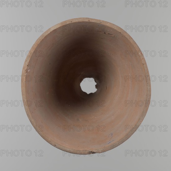 Bowl. Vessel flower pot with a conical shape and a flat bottom. Irregular walls. Straight, flat, slightly flaring, asymmetrical rim. Made on the wheel of Nile clay type NB2 Vienna System. Irregular bottom, cut off with a string; 3.2 cm diameter hole in the bottom. Potter's fingerprints as clear indentations in the lower part of the vessel next to the bottom. Smooth surface. Reddish-brown clay. Condition good, with only minor damage to the rim. ca. 1550–ca. 1069 BC New Kingdom, Deir el-Medina. Height 18 cm; rim diameter 15.8 cm; bottom diameter 9.5 cm., A view looking into a round, hollow, cylindrical object made of clay with a rough, matte surface showing earthy brown and terracotta tones, with darker brown areas toward the center and subtle variations of reddish-brown and beige along the inner walls; the rim shows a few small chips and rough edges in similar brown colors, and a small irregular hole is visible at the far end revealing a pale gray background; the surrounding background ...