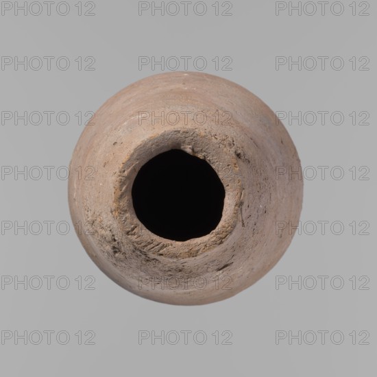 Vessel, Egyptian pottery ceramic clay vessel, New Kingdom, from Deir el-Medina; vessel, height 18.5 cm, rim diameter 5.2 cm, body diameter 10.2 cm., A round, weathered clay vessel seen from above with a dark central opening, showing a rough, textured rim and surface; the vessel is predominantly light brown with variations of tan and beige, and the background is a uniform light gray.