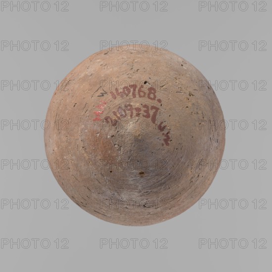 Vessel, Egyptian pottery ceramic clay vessel, New Kingdom, from Deir el-Medina, vessel, height 18.5 cm, diameter 5.2 cm rim, diameter 10.2 cm body, A roughly spherical, worn object with a textured, pitted surface in shades of brown, tan, and beige sits against a plain light gray background; there are a few small darker spots and a few areas with reddish and faint whitish discoloration on the object's surface.