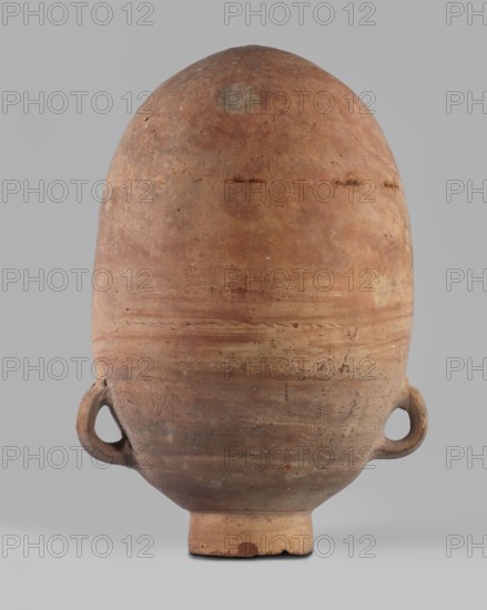 Vessel, Storage vessel amphora with an ovoid body, rounded bottom, and short cylindrical neck. Small handles glued to the sides. Straight rim. Smoothed surface with an imprint of a thin cord about halfway up. Surface color red to dark red. Complete with isolated losses on the rim and three holes in the vessel walls. Egyptian amphora made of Nile clay, possibly from Thebes. Likely developed from Third Intermediate Period storage vessels and probably used as a water container. Analogous examples are known from Amarna, Qau el-Kebir, Matmar, Elephantine, Hermopolis, Herakleopolis, Abydos, and Deir el-Medina. Dimensions: height 47.2 cm; rim diameter 11.7 cm; belly diameter 30.2 cm. Date: Third Intermediate Period 25th Dynasty, ca. 1069–664 BC., An oval-shaped pottery vessel with a rounded top and a narrower base stands against a plain light-gray background, showing a weathered clay surface in shades of brown, tan, reddish-brown, and muted gray; the vessel has a pair of rounded loop handles ...