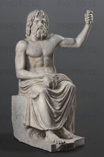 Statue of Jupiter of the Capitoline type, unknown Roman workshop. Jupiter Zeus seated on a throne set on a rectangular base. Seated stiffly with torso slightly reclined; raised left hand holds a scepter, right hand rests on right knee, right foot slightly forward. Legs covered with a himation that also covers the back and left shoulder. Muscular torso strongly developed at the shoulders with naturalistic modeling. Head disproportionately large; face nearly idealized with a slightly open mouth. Hair parted from the center anastole. Thick beard arranged in strands on the sides and in curls on the chin. Roman copy after a Hellenistic variant of Phidias's statue of Zeus the Olympian. Sculpture, late 2nd–3rd century AD Roman Empire. Weight 930 kg., A marble statue of a seated bearded man with long wavy hair, shown from head to feet, posed with one arm raised and the other resting on his lap; he wears a draped garment over his lower body that creates flowing folds, and his exposed torso show...