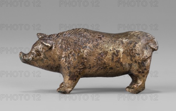 A small bronze figurine of a pig. The animal stands on rather schematically depicted legs ending in forward-pointing hooves. The animal's massive body is characterized by an unnatural length. The torso is adorned with a small, doubled tail. The presence of hair is clearly marked on the animal's back. The pig's muzzle, set on a thick neck, ends in a narrow snout. The pig's slightly protruding ears point forward. The animal's eyes, which are unusually large relative to the rest of the body, are clearly marked. The sculpture is covered with a natural patina. The figurine was probably used as a votive offering primary or secondary; this interpretation is supported by its finding in the vicinity of the temple. Hellenistic period, Kyrene Libya. Figurine. Height 1.8 cm; width 4.2 cm; depth 1.4 cm; weight 0.035 kg., A small sculpted animal figure with a rounded body and short legs, rendered in metallic tones of brown, bronze, and gold with darker brown and black spots and patches; the surface ...