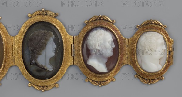 Bracelet with cameos, maker, Roniker, E. purchased. Portraits, gems, goldsmithery; Roman period/19th century AD. Jewelry; height 4.2 cm, width 19.5 cm., A horizontal arrangement of three oval framed cameos set in an ornate gold-colored decorative hinge, each cameo showing a profile bust facing right; the leftmost cameo has a dark background with a lighter profile wearing a draped head covering in shades of black and grey, the central cameo has a brownish background with a white sculpted bust showing curly hair and a beard, and the rightmost cameo has a white carving of a youthful profile against a pale backdrop; the frames are gold with embossed floral and scrollwork decoration, and the overall background is a muted grey.