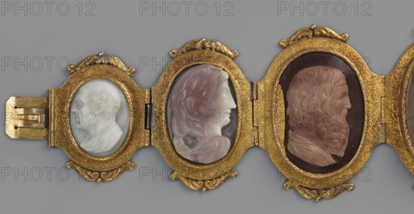 Bracelet with cameos; maker, Roniker, E. - purchased; portraits, gems, goldsmithery; Roman period/19th century AD; place of origin, jewelry; height 4.2 cm; width 19.5 cm, A horizontal close-up shows a decorative hinged panel with a group of three oval portraits set in ornate frames. The frames are metallic and golden with engraved scrollwork and curving embellishments. Each oval contains a carved profile relief: the left relief is white with subtle gray shading and depicts a bald head and draped clothing; the center relief has pale pink and off-white tones with a smooth face and flowing hair; the right relief is in warm reddish-brown and pale flesh tones showing a bearded face and textured hair, set against a dark background. The visible colors include gold, white, gray, pink, reddish-brown, pale flesh tones, dark brown, and muted gray in the surrounding background.