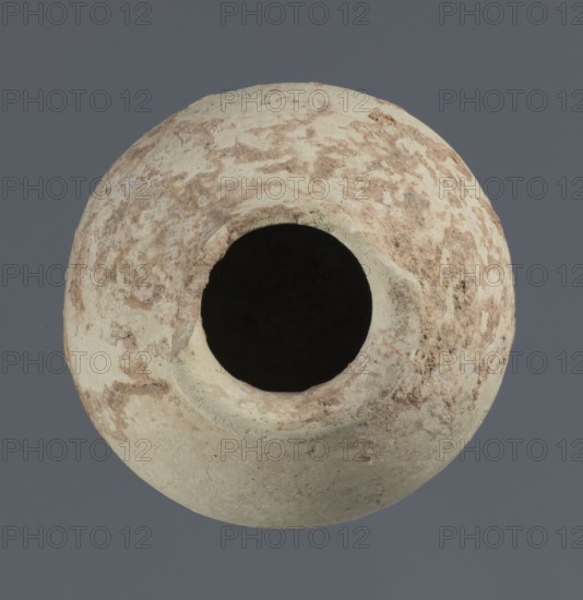 Spherical vessel, unknown northern Mesopotamian workshop; clay; Early Jazira III period ca. 2600–ca. 2350 BC; Early Dynastic III period; spherical vessel with an egg-shaped belly, rounded bottom, low cylindrical neck ending with a thickened rim turned outwards; Northern Mesopotamia Khabur basin, Tell Rad Shakra North-Eastern Syria; height 7.8 cm, width 6.5 cm., A round ceramic vessel viewed from above showing a central wide opening and worn textured surface with patches of pale beige and light brown mottling against a solid muted gray background.