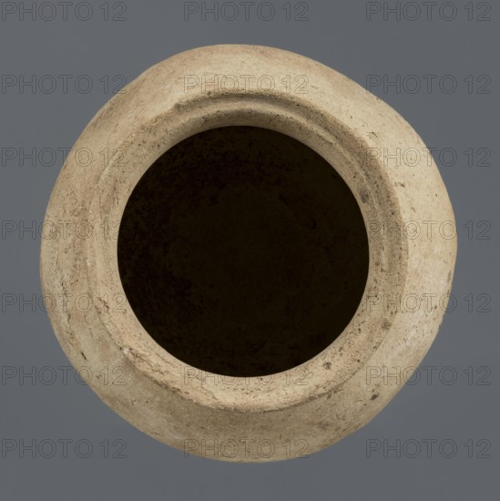 Spherical vessel, unknown northern Mesopotamian workshop, Early Jazira III period ca. 2600–ca. 2350 BC / Early Dynastic III period. A spherical vessel with a pear-shaped, tapering body and rounded bottom, strongly sloping shoulders passing into a low, wide neck ending with a thickened rim on the outside in the form of a wide rectangular strip whose rounded outer edge protrudes above the inner surface of the neck, creating a lowered step for a lid. On the lower part of the body a pottery mark was carved before firing: two long lines intersecting at the bottom at an acute angle, forming a mark resembling a deformed letter Y. c. 2600–c. 2350 BC; Syria, Northern Mesopotamia Khabur basin, Tell Rad Shakra northeastern Syria. Vessel; clay; height 25.5 cm, width 24.6 cm., A top-down view of a round ceramic vessel with a wide open mouth, showing a textured, rough surface in beige and tan tones and an interior that appears very dark brown to black, set against a flat gray background.