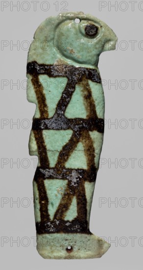Amulet - Kebehsenuf element of a mummy net, Kebehsenuf myth., Sons of Horus myth., mummies, grave goods, Presumably an amulet from a mummy net, 664–332 BC; Late Period, Egypt, amulet, height 7.1 cm, width 2.6 cm, A vertical, narrow object shaped like a stylized bird with a rounded head and beak, rendered in pale green with a glossy, slightly weathered surface; the object is marked by several broad, dark brown bands forming a lattice-like pattern down its length, with areas of darker, almost black mottling and some whitish encrustations; there are a couple of small holes near the top and bottom edges, and a few chips and irregular edges where the material is worn away; the background is a uniform light gray.