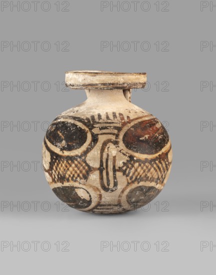 Orientalizing aryballos, Late Corinthian period, with a belt vice, 580–550 BC dated to 580–550, Late Corinthian I, Corinth; vessel aryballos; height 6.8 cm, width 6.2 cm., A rounded ceramic vessel with a short neck and a flat rim sits against a plain gray background. The vessel shows a painted decorative scheme in black, brown, and cream tones, including several large circular motifs and crosshatched patterns. The rim and neck area are cream with aged, worn edges, and the body features alternating dark circular panels and lighter areas with linear and curved black markings. The surface appears weathered with chips and faded paint, and shadows beneath the vessel indicate it is resting on a flat surface.