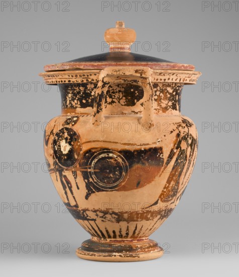 Column krater with lid, unknown Attic workshop. Black-figure krater with lid. Red clay, tinted with ochre. Black firnis with a muted lustre, fading to brown in places. The rim of the vessel is decorated with a radial ornament and a schematic ivy sprig. On the shoulders are a series of vertical lines. The belly is decorated with figural scenes. On side A, Dionysus with a cornucopia is shown, accompanied by a satyr and a maenad. On side B an archer is depicted between two helmeted hoplites with round shields. A lid with a pomegranate-shaped handle, decorated with an ivy sprig placed on the rim. 520–510 BC, Attica. Vessel, column krater. Weight 1.382 kg; diameter 19.2 cm 22.5 cm with vices; height 21.4 cm 22.6 cm with vices., An aged ceramic vessel with a rounded body, a flared rim and a lid topped by a rounded knob, showing worn areas and flaking surface decoration; the piece displays a palette of terracotta orange, black, and pale beige with patches where the darker pigment has been rub...