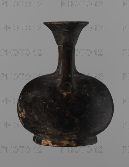 Aryballus lekythos, Reddish-brown clay with black, slightly shiny, well-covering varnish, also on the underside of the foot and inside the handles. Low echinus-shaped foot, spherical slightly flattened body; low narrow neck with a funnel-shaped rim with a thickened lip. Body decoration: bird in left profile with beak raised. Ceramics, red-figure pottery; Greek pottery, ancient vessel lekythos / aryballus. Southern Italy, 4th century BC 2nd half of the 4th century BC. Height 9.3 cm, width 7.6 cm., A dark rounded vessel with a narrow neck and flared rim, showing worn areas and patches where the surface is lighter; the vessel is primarily black with spots of brown and tan wear, set against a uniform gray background.