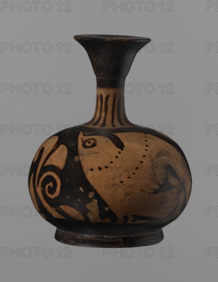 Aryballus lekythos, Ancient Greece, antiquity. Bird iconography. Ceramics; red-figure pottery; Greek pottery; ancient vessel; lekythos; Southern Italy. Reddish-brown clay with black, slightly shiny, well-covering varnish, also on the underside of the foot and inside the handles. Low echinus-shaped foot; spherical, slightly flattened body. Low, narrow neck with a funnel-shaped rim with a thickened lip. Body decoration: bird in left profile with beak raised. 4th century BC. Aryballus lekythos vessel. Height 9.3 cm; width 7.6 cm., A rounded ceramic vessel with a narrow flared neck sits against a plain gray background, showing a palette of black and tan with areas of lighter brown wear; the neck is primarily black with vertical tan stripes, the bulbous body features sweeping black painted motifs and dotted patterns on a tan field, and the base is dark with signs of surface aging and small patches where the black paint has worn away.