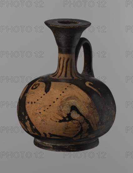 Aryballus lekythos, Ancient Greece, antiquity; Southern Italy, 4th century BC. Reddish-brown clay with black, slightly shiny, well-covering varnish also on underside of foot and inside handles. Low echinus-shaped foot; spherical, slightly flattened body; low narrow neck with funnel-shaped rim with thickened lip. Body decorated with a bird in left profile with beak raised. Lekythos/aryballus; ceramics, red-figure pottery, Greek pottery, ancient vessel. Height 9.3 cm, width 7.6 cm., A rounded ceramic vessel with a narrow neck, flaring rim, and single curved handle, shown against a plain gray background; the body is primarily a warm tan color with large areas of black decoration and blackened sections on the neck, rim, handle, and base, and there are a few dotted decorative elements and swirling black painted motifs on the tan surface.