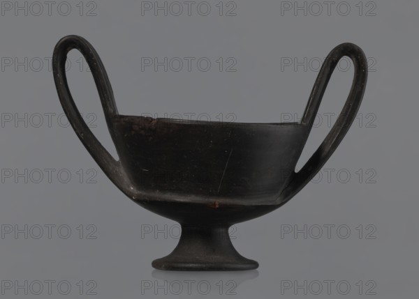Kantharos, black-varnished on a cup-shaped foot, vessel goblet used for banquets; 1st half of the 6th century BC, Etruria Italy., Repossession provenance: Bytom., A black, bowl-shaped vessel with a rounded foot and a pair of high, curved handles extending upward and outward, set against a gray background; the surface shows worn areas and slight scratches and there are subtle brownish tones in a few spots.