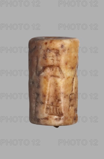 Cylinder seal with a presentation scene and a cuneiform inscription, unknown Akkadian workshop; Mardati scribe. Presentation scenes: cylinder with a negatively engraved presentation scene showing three male figures, one seated and two standing in front of him. Behind the seated figure are two vertical frames with cuneiform characters. The seated figure on a throne, damaged is shown in left profile, dressed in a kaunakes-type robe and wearing a headdress with a single pair of horns typical of deities; the right hand is raised in a gesture of greeting toward the approaching figures. In front of him is an altar or censer; in the upper register is a crescent moon. Behind the altar stands a figure in right profile, wearing a long robe finished with fringes; the left arm is bent at the elbow and raised to face level in greeting, the right arm bent at the elbow is at waist level. Behind the deity a standing figure in right profile wears a long fringed robe; his lowered left hand holds a bucke...