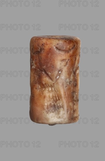 Cylinder seal with a presentation scene and a cuneiform inscription, unknown Akkadian workshop; maker: Mardati scribe. Cylinder with a negatively engraved presentation scene showing three male figures, one seated and two standing before him. Behind the seated figure are two vertical frames with cuneiform characters. The seated figure on a damaged throne is in left profile, wearing a kaunakes-type robe and a headdress with a single pair of horns typical of deities; the right hand is raised in a gesture of greeting toward the approaching figures. In front of him is an altar or censer, and in the upper register is a crescent moon. Behind the altar stands a figure in right profile wearing a long robe with fringes; the left arm is bent and raised to face level in greeting, the right arm bent at the elbow is at waist level. Behind the deity, a standing figure in right profile wears a long robe with fringed hem; his lowered left hand holds a bucket or basket, and his right hand, bent at the e...
