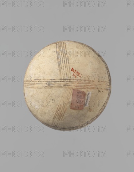 Jug, unknown Cypriot workshop. White painted ware jug with a spherical bottom, a bulging pear-shaped body transitioning in the upper part into two tubular spouts with protruding walls. Between them, a ring-shaped vise protrudes from the body. The vessel is covered with white paint and decorated with brownish-red paint. A zigzag ornament runs around the body for one-third of the vessel's height, flanked on each side by two horizontal lines. Below are four bands of lines converging at the bottom. The upper part of the body is decorated with four stripes filled with diagonal, intersecting lines; the stripes are separated by serpentine winding lines. The vise is decorated with diagonal lines at the top and brown paint on the sides. At the base of the rims, a zigzag ornament is framed by two lines on either side; above it, vertical lines surround the rims both inside and outside. Bronze Age, 1900–1650 BC, Cyprus. Vessel; height 15 cm, width 13 cm., A round, shallow bowl viewed from above wi...
