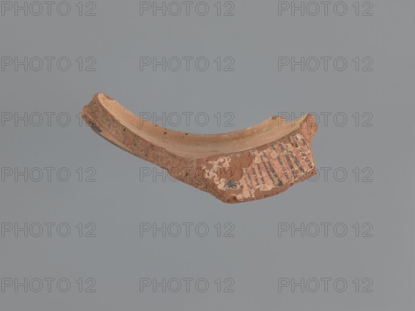 Fragment of a vessel stand, painted Coptic vessel stand with floral decorations. Walls formed into a hoop with the diameter of the upper edge slightly larger than the lower. Decoration painted in black and red on a beige whitewash background. Lower edge bulges outward and inward in the form of a half-cylinder; its outer surface decorated with a black horizontal band. Upper edge has an outward rim; its horizontal outer surface decorated with a red band bearing several black dots and a series of lines perpendicular to the rim. Exterior decorated with almond-shaped, stylized, unevenly sized plant elements with pointed tips upward; each almond-shaped motif filled with a grid of black lines and surrounded by two or three groups of arcuate lines repeating its shape. Made of medium-porous Nile clay. 6th–7th century, Tell Atrib; vessel. Height 8.5 cm, width 13.7 cm, lower outer rim diameter 24 cm, upper outer rim diameter 25 cm., A broken curved fragment of reddish-brown clay with a rough text...