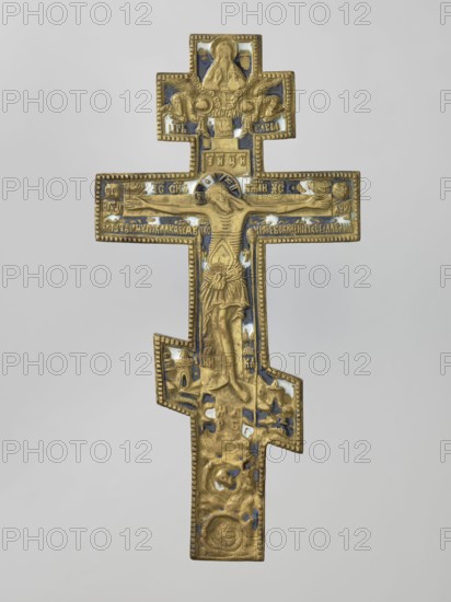 Cross: Crucifixion of Christ, Old Believers workshop; crosses; Jesus Christ Bible; Lord of Hosts iconography; God the Father iconography; moon iconography; Crucifixion iconography; sun iconography; Adam Bible; Golgotha iconography; skull iconography; instruments of the Passion of the Lord iconography; Jerusalem Israel/Palestine; Holy Spirit iconography; ornaments; inscriptions; halo iconography. On the eight-pointed cross is an image of the Crucifixion. Below the cross on which Christ is suspended is a grotto with Adam's skull and the tree of Seth; at the level of the footstool is a view of Jerusalem; on two sides of Christ on a long beam are the sun and the moon. In the upper part is a bust-like image of the Lord of Hosts, below which is depicted the dove of the Holy Spirit. The casting is rough. The background is navy blue, sky blue, and white enamel. The reverse is engraved with the words of a prayer to the Holy Cross and an image of an eight-pointed cross. 19th century, Russia. Cro...