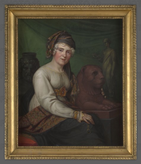 Helena Radziwill, née Przezdziecka 1753–1821, painted by Ernst Gebauer 1782–1865. Seated, body three-quarters, head facing viewer. Wearing a turban made of a navy blue shawl with gilded border falling over the left shoulder; white dress with gold embroidery at neckline and cuffs; gold belt under the bust with a large beaded leaf-shaped buckle. Legs covered with dark fabric finished at the top with a wide border with rich geometric and floral ornament. Right hand rests on lap holding a monocle on a chain; left hand embraces the figure of a reclining lion on a pedestal. Background: dark curtain with a figure in antique costume at right and a vase at left. Ca. 1816, Berlin. Portrait. Unframed: H 101.5 cm, W 84.5 cm; with frame: H 117.2 cm, W 84.5 cm., A seated woman with pale skin and white curled hair wears a patterned headscarf and a light-colored blouse with decorative trim, a richly patterned shawl in shades of red, orange, and green draped over her lap, and a dark skirt; she faces fo...
